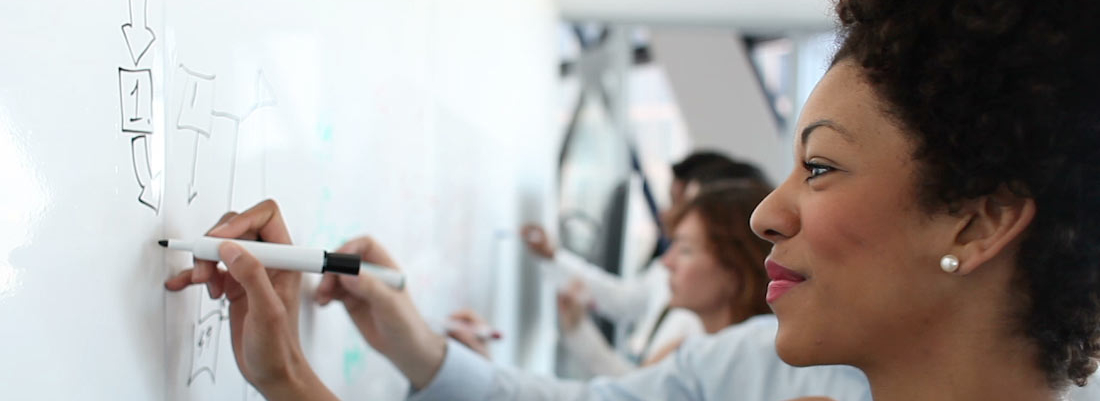 Training class writing on whiteboard.